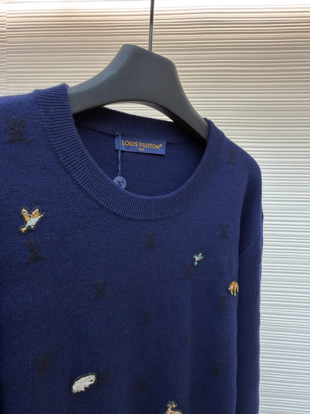LOUIS VUITTON animal embroidered wool crew neck sweater ●Original version: purchased and developed by 18025 ●Item number: 1682089-B05 ●Fabric: wool blended fabric ●Technology: knitted embroidery production ●Color: navy blue ●Version: fitted version ●Weight: about 590 grams ●Size: XS-S-M-L ●Description: This Louis Vuitton navy blue sweater is made of ultra-fine merino wool blended yarn and is knitted by worsted knitting technology. It uses 16-needle high-density plain knitting technology to give the fabric a silky delicate touch and matte texture. The base of the body is also woven with a mini Monogram pattern using a same-color dark jacquard technology. The pattern is low-key and naturally blends with the wool texture. The decorative details embellished on the body are made of hand-made beading and metal veneer inlays. The veneer is aged by electroplating and enamel color-filled. Every decoration is hand-positioned and sewn by craftsmen to ensure firmness and a beautiful arrangement. The round neckline adopts double-needle overlock knitting technology, which is not easy to deform and fits the neck. The side seams and hem of the body use seamless splicing technology to reduce friction when wearing. The overall stitching is even and fine, fully demonstrating the brand's exquisite craftsmanship and detail control in the field of knitted garments. The overall wiring is straight and delicate, the fabric is comfortable and soft, and the color is consistent without color difference. It can be matched with the same style to create a fashionable look and control various occasions. Customized accessories, complete with three standards, same style for men and women!